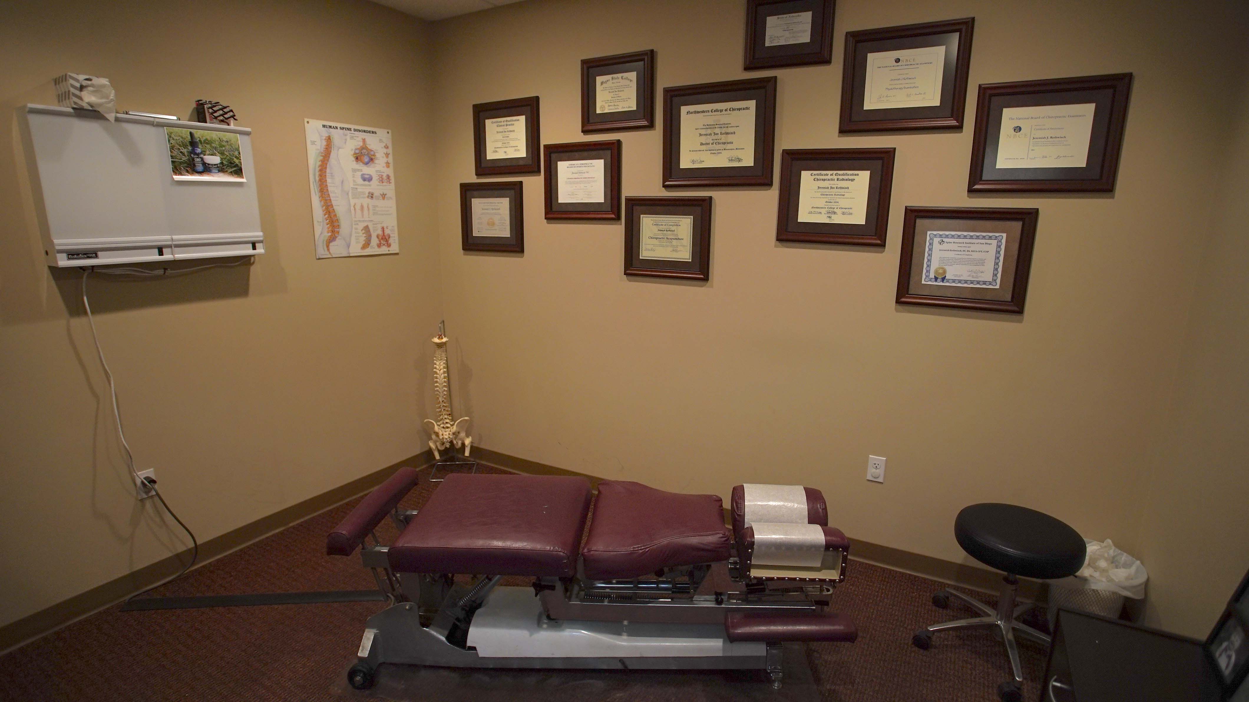 Treatment room with adjusting table and plaques on wall